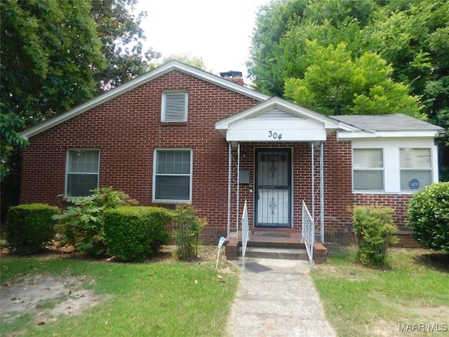 304 Patterson St, Tuskegee, AL 36088 - view of front of house with a chimney and brick siding