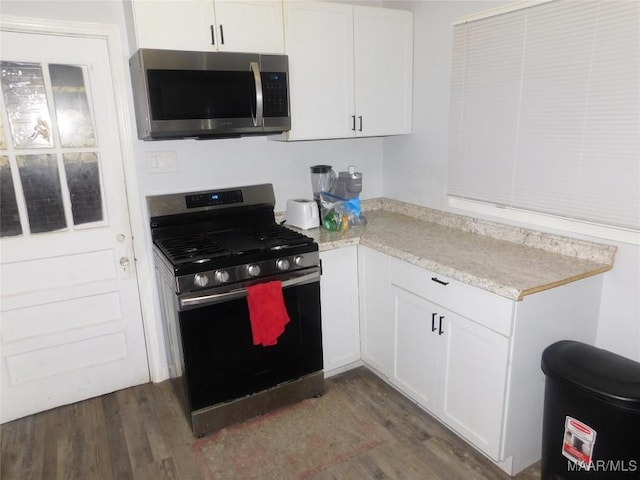 304 Patterson St, Tuskegee, AL 36088 - kitchen with appliances with stainless steel finishes, dark wood-style floors, white cabinetry, and light countertops