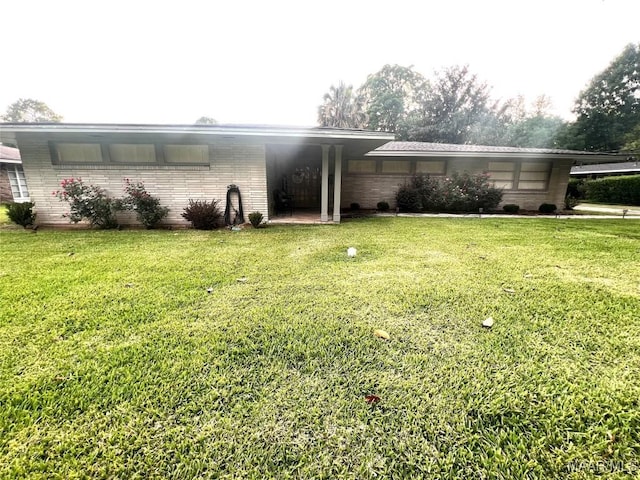 3628 Bankhead Ave, Montgomery, AL 36111 - view of home's exterior with brick siding, a lawn, and a carport