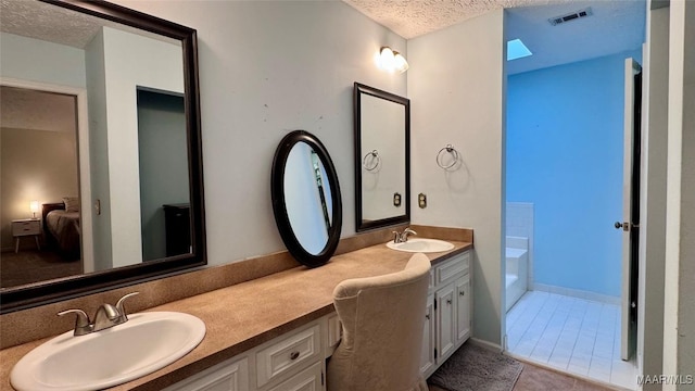 6537 Monmouth Mews, Montgomery, AL 36117 - ensuite bathroom with a textured ceiling, double vanity, a bath, and tile patterned floors