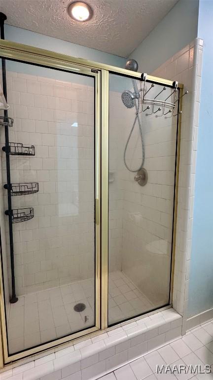 6537 Monmouth Mews, Montgomery, AL 36117 - bathroom featuring a stall shower, a textured ceiling, and tile patterned floors