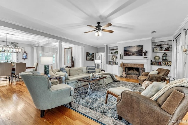 9021 Creek Side Trl, Hope Hull, AL 36043 - living room featuring decorative columns, ceiling fan, wood finished floors, a fireplace, and ornamental molding