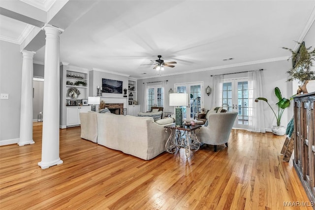 9021 Creek Side Trl, Hope Hull, AL 36043 - living room with a ceiling fan, a fireplace, light wood-style flooring, ornate columns, and ornamental molding