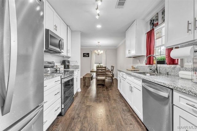 5777 Carriage Barn Ln, Montgomery, AL 36116 - kitchen featuring stainless steel appliances, ornamental molding, a chandelier, dark wood-style floors, and white cabinetry