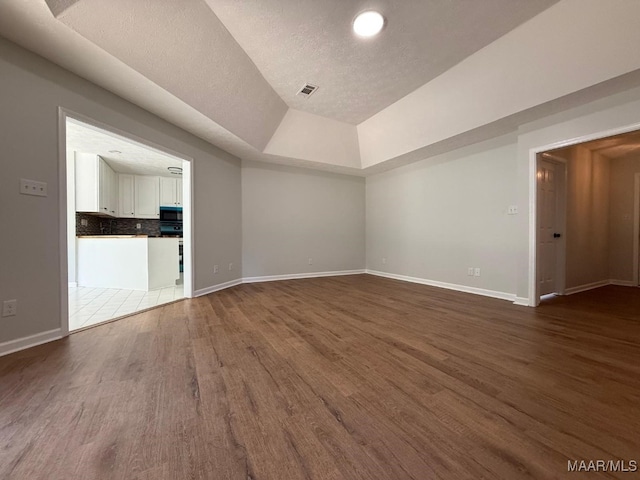 6524 Foxleigh Ct, Montgomery, AL 36116 - spare room with wood finished floors, a textured ceiling, and lofted ceiling