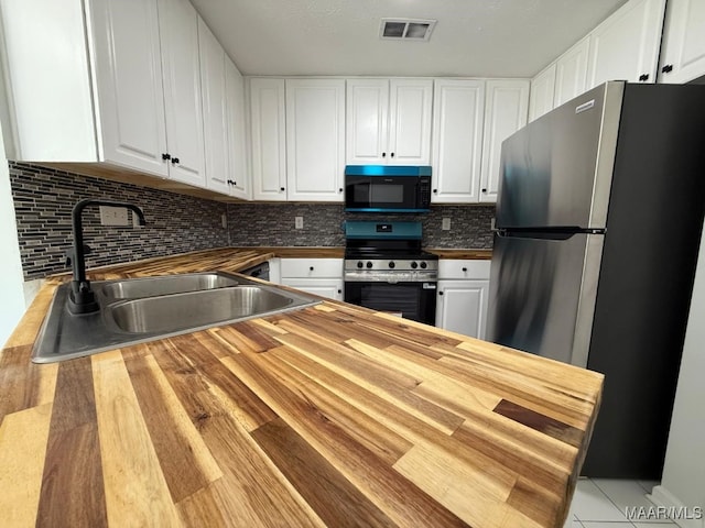 6524 Foxleigh Ct, Montgomery, AL 36116 - kitchen with appliances with stainless steel finishes, butcher block counters, white cabinets, tasteful backsplash, and tile patterned floors