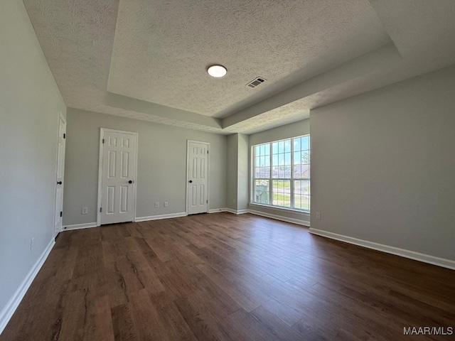 6524 Foxleigh Ct, Montgomery, AL 36116 - empty room featuring a raised ceiling, a textured ceiling, and dark wood finished floors