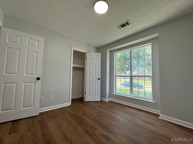 6524 Foxleigh Ct, Montgomery, AL 36116 - unfurnished bedroom with a textured ceiling and dark wood-style flooring