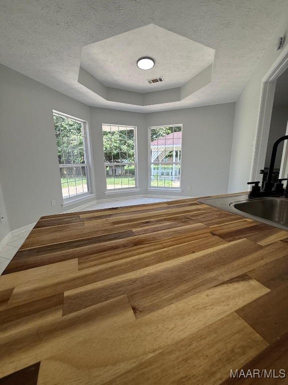 6524 Foxleigh Ct, Montgomery, AL 36116 - unfurnished room featuring a tray ceiling, a textured ceiling, and wood finished floors