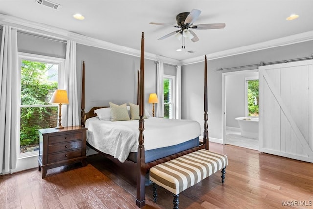 1613 Croom Dr, Montgomery, AL 36106 - bedroom with crown molding, wood finished floors, a barn door, recessed lighting, and connected bathroom