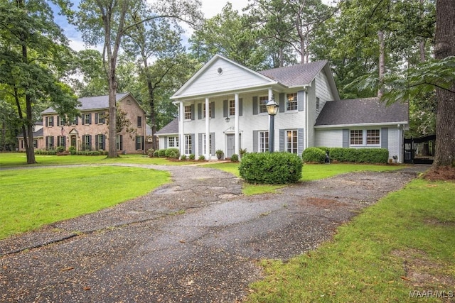 1613 Croom Dr, Montgomery, AL 36106 - neoclassical home featuring a front lawn, driveway, covered porch, and a shingled roof