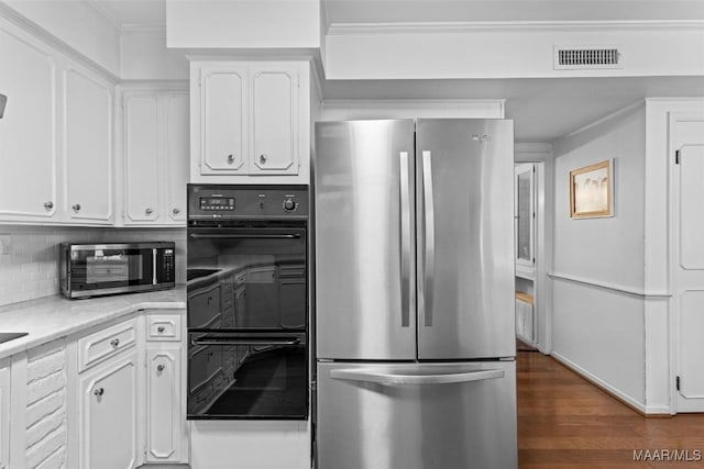 1613 Croom Dr, Montgomery, AL 36106 - kitchen with appliances with stainless steel finishes, decorative backsplash, white cabinets, light countertops, and dark wood-type flooring