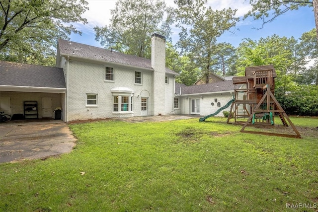 1613 Croom Dr, Montgomery, AL 36106 - rear view of property with a chimney, a carport, a lawn, and a playground