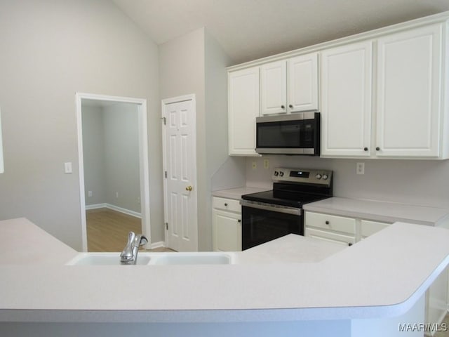 9467 Greythorne Way, Montgomery, AL 36117 - kitchen with stainless steel appliances, white cabinetry, light countertops, vaulted ceiling, and wood finished floors