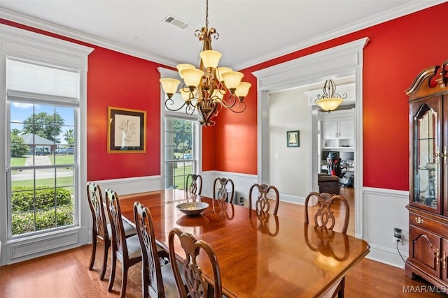 760 Winding Wood Dr, Wetumpka, AL 36093 - dining room with a chandelier, a wainscoted wall, plenty of natural light, wood finished floors, and ornamental molding