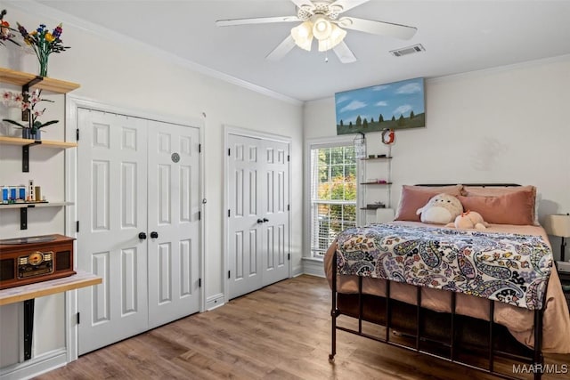 760 Winding Wood Dr, Wetumpka, AL 36093 - bedroom featuring two closets, wood finished floors, crown molding, and ceiling fan