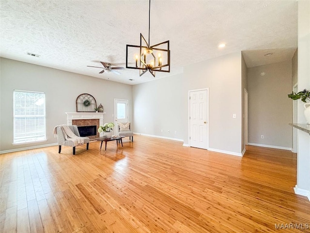 9642 Greythorne Way, Montgomery, AL 36117 - living area featuring light wood-style flooring, a premium fireplace, a chandelier, ceiling fan, and a textured ceiling