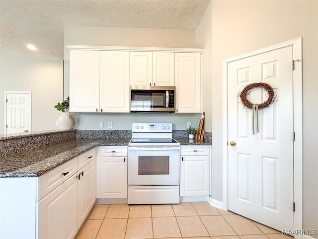 9642 Greythorne Way, Montgomery, AL 36117 - kitchen with stainless steel microwave, electric stove, light tile patterned floors, a peninsula, and white cabinets