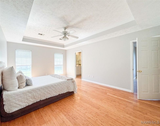 9642 Greythorne Way, Montgomery, AL 36117 - bedroom with a raised ceiling, a textured ceiling, multiple windows, light wood-style floors, and ceiling fan
