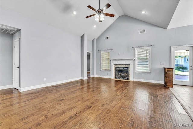 2285 Gathering Way, Prattville, AL 36066 - unfurnished living room featuring a ceiling fan, high vaulted ceiling, wood finished floors, a stone fireplace, and recessed lighting