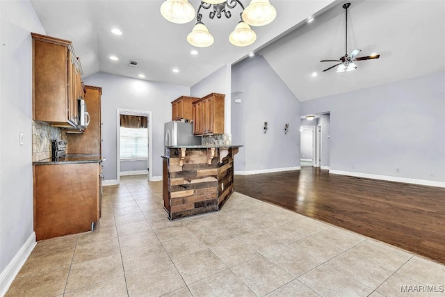 2285 Gathering Way, Prattville, AL 36066 - kitchen featuring light tile patterned floors, brown cabinetry, open floor plan, decorative backsplash, and high vaulted ceiling