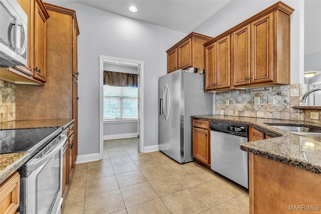 2285 Gathering Way, Prattville, AL 36066 - kitchen featuring brown cabinets, stainless steel appliances, backsplash, dark stone countertops, and recessed lighting