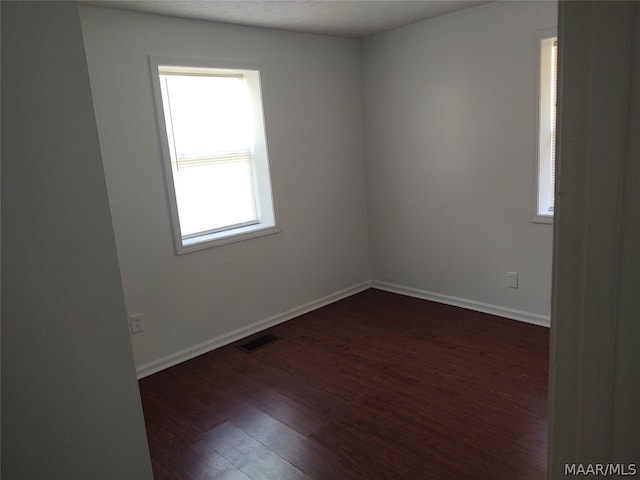 spare room featuring dark wood-type flooring