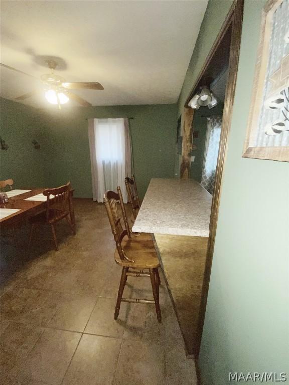 dining space featuring light tile flooring and ceiling fan