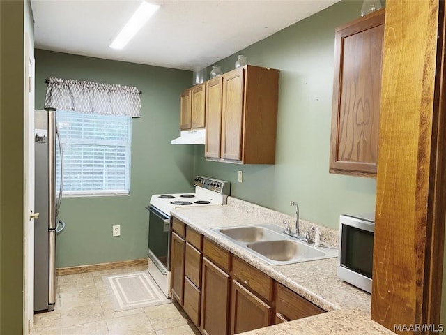 kitchen with appliances with stainless steel finishes, sink, and light tile floors