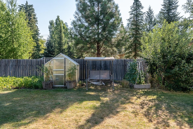 772 Cedar St, Whitefish, MT 59937 - view of yard featuring a greenhouse, an outdoor structure, and a garden