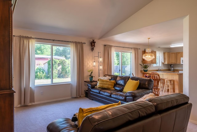 772 Cedar St, Whitefish, MT 59937 - living room with a chandelier, light carpet, baseboards, and vaulted ceiling
