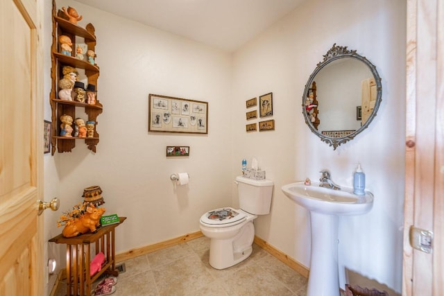 bathroom featuring tile flooring and toilet