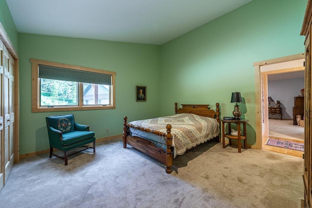 bedroom featuring a closet, light colored carpet, and vaulted ceiling