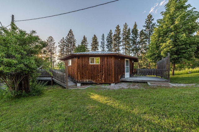 exterior space featuring an outdoor structure and a lawn