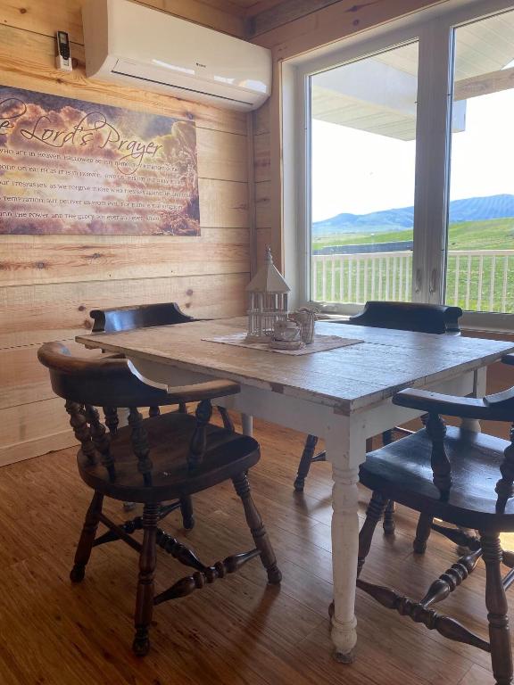 dining area featuring wooden walls, a mountain view, a wall mounted AC, and dark wood-type flooring