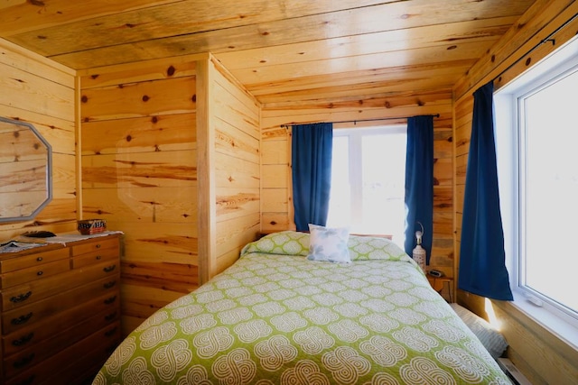 bedroom featuring wooden walls, multiple windows, and wooden ceiling