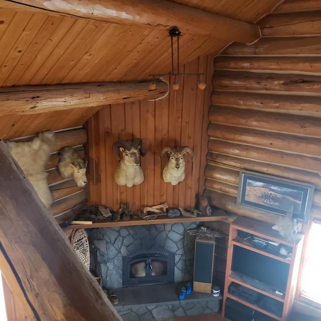 interior details featuring wooden ceiling, beam ceiling, rustic walls, and a stone fireplace