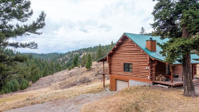 view of property exterior with a wooden deck and a garage