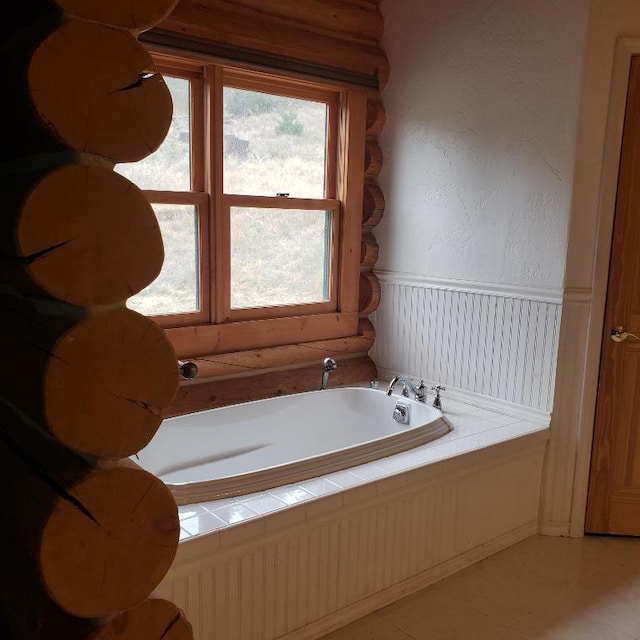 bathroom featuring a bath, tile floors, and log walls