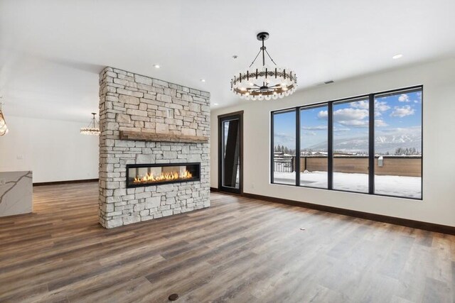 unfurnished living room with plenty of natural light, dark hardwood / wood-style floors, and a stone fireplace