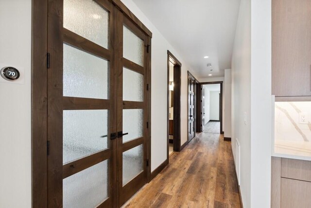 hallway featuring french doors and wood-type flooring