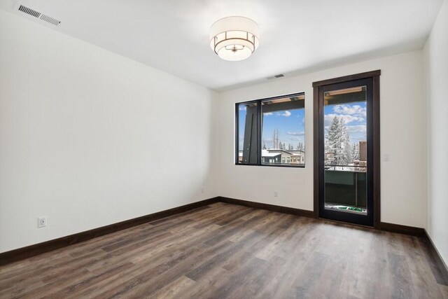 empty room with dark hardwood / wood-style flooring