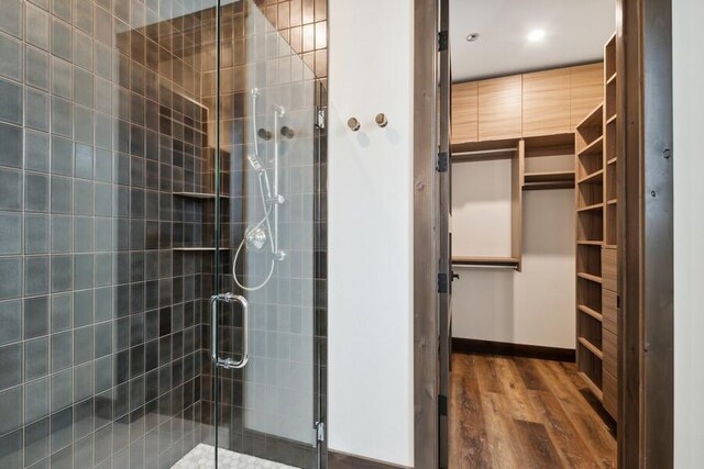 bathroom featuring a shower with door and wood-type flooring