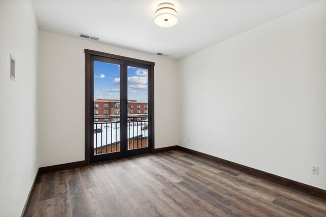 empty room featuring french doors and hardwood / wood-style flooring