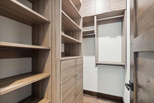 spacious closet with light hardwood / wood-style floors