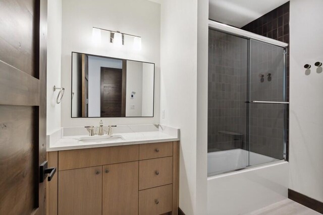 bathroom with enclosed tub / shower combo and vanity