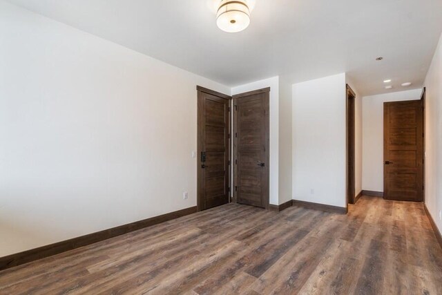 unfurnished bedroom with dark hardwood / wood-style flooring and a closet