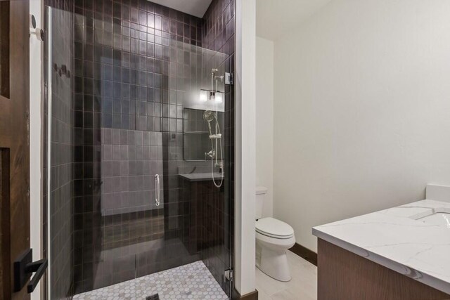 bathroom featuring tile patterned floors, a shower with shower door, vanity, and toilet