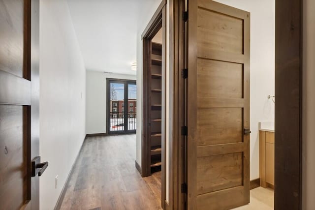 hallway with light hardwood / wood-style floors