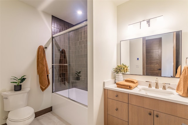 full bathroom with bath / shower combo with glass door, vanity, and toilet